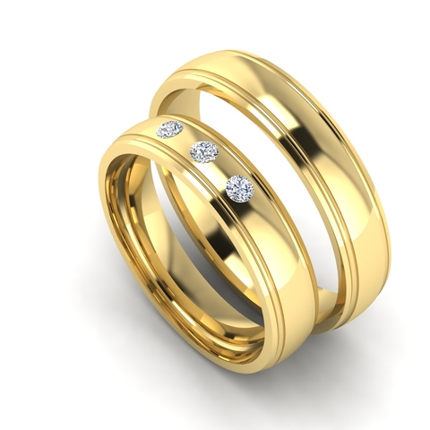 Conjunto de alianças de casamento em ouro, uma com três diamantes.