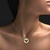 Colar de ouro 18k com pingente redondo do Espírito Santo adornado com diamantes e rubi, usado no pescoço de mulher