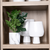Jarron florero color blanco para plantas posando en cajon de madera junto con otros jarrones