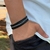 PULSEIRA DE COURO PRETO NÃO AJUSTÁVEL 2 TRANÇADOS 1 TRANÇADO BRANCO E PRETO 1 TIRA LISA
