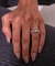Aliança Navetes com pedras em Zircônias usada como aparador de aliança de uma mão feminina com unhas pintadas de nude. 