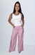 Modelo vestindo calça cintura alta de alfaiataria rosa com blusa branca, destacando um look elegante e moderno.