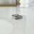 Anillo plateado cruzado con zirconias
