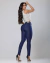 Modelo vestindo calça skinny jeans azul escuro, com blusa de alça, exibindo a parte de trás da peça.