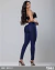 Mulher usando calça skinny jeans azul escuro levanta bumbum Super Power Tóka.21, vista de costas, com top preto e salto alto preto.