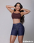 Bermuda feminina de meia coxa em tom escuro, combinada com um top cropped marrom, apresentando um modelo moderno e estiloso.