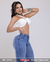 Modelo feminina usando calça skinny jeans levanta bumbum na cor delave, com top branco e acessórios metálicos.
