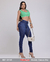 Modelo feminina usando calça skinny de cintura alta na cor jeans, com blusa verde e acessórios elegantes.