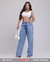 Modelo feminina usando calça wide leg azul clara, blusa cropped branca e acessórios, segurando uma bolsa branca.