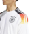 Camisa branca da Seleção da Alemanha, modelo masculino da Adidas, com detalhes em vermelho e preto nas mangas.