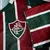 Camisa Fluminense I 24/25, com as cores verde e vermelha, exibindo o escudo do clube.