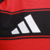Logotipo da Adidas em uma camisa do Flamengo, com detalhes em preto e vermelho.