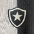Detalhe do escudo do Botafogo em uma camisa preta e branca da Reebok, temporada 24/25.
