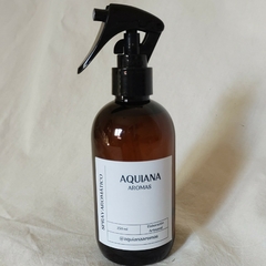 Frasco de spray aromático de la marca Aquiana, con etiqueta blanca y tapa negra.