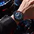 Relógio Curren masculino com pulseira azul e mostrador azul escuro com detalhes vermelhos no pulso de homem usando jaqueta preta