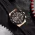 Relógio de pulso masculino com pulseira preta de silicone e mostrador preto com detalhes em dourado e vermelho