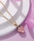 Collar con un dije de corazón rosa en internet