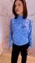 Mulher usando blusa de tricô modal azul com bolsos, em fundo claro.