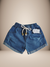 Shorts jeans infantis de tecido azul com detalhes desfiados e cordão na cintura, sobre fundo de pelúcia branca.
Descubra a Flor do Gato, loja de roupas infantis em Taubaté, Pindamonhangaba, Caçapava e Tremembé, com moda de qualidade e estilo para bebês e 