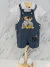 Conjunto infantil temático Mickey Realeza para aniversário de 1 ano, com jardineira azul escura bordada com Mickey sentado em trono e body branco com gola polo, acompanhado de sapatinhos brancos