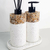 Kit lavabo Atenas composto por dois frascos com base de cimento e tampas pretas, decorados com pedras naturais, em um suporte branco.