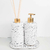 Kit lavabo Milão com dois dispensadores brancos com detalhes em dourado e varetas de aromatização.