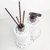 Conjunto de lavabo Milão com dois dispensadores brancos de material texturizado e hastes escuras.