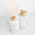 Kit Lavabo Milão com dispenser de sabonete e difusor de aromas em base de textura branca com detalhes dourados.