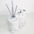 Kit Lavabo Milão com dispenser e varetas aromáticas em um suporte branco com detalhes em preto.