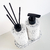 Kit Lavabo Milão composto por frascos brancos com detalhes pretos e palete, decorado com varetas aromáticas.