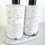 Kit Lavabo Safira composto por dois frascos em formato cilíndrico com detalhes em azul e uma base circular, ideal para decoração de lavabos.