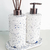 Kit lavabo Safira com dois dispensadores em formato cilíndrico, um com bomba e outro com varetas aromáticas, sobre uma base branca.
