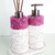 Conjunto de itens de lavabo com acabamento em cristais roxos e base branca, incluindo um difusor e um dispenser de sabonete.