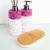 Conjunto de produtos de lavabo com frascos decorativos em cristais roxos e base de cortiça.