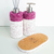 Conjunto de itens para lavabo, incluindo um dispenser de sabonete e um difusor de aromas com base em material branco e detalhes em cristais roxos.