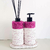 Kit Lavabo Malaya com dois dispensers decorativos e suporte, adornados com detalhes em pedras rosa.