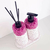 Kit Lavabo Malaya com frascos decorativos com pedras rosa e suporte branco.
