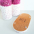 Kit Lavabo Malaya composto por dois recipientes decorativos com textura rosa e branca e uma base de cortiça.