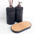 Kit lavabo Roma composto por dois frascos para sabonete e difusor de aroma, com base em material escuro e texturizado, acompanhado de uma bandeja de cortiça.
