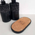Kit Lavabo Roma composto por dois frascos pretos decorativos com texturas artesanais e uma base de cortiça.