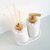 Kit lavabo Santorini com dois frascos decorativos, um com difusor e outro com bomba, ambos adornados com pedras brancas e detalhes em dourado.