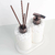 Kit Lavabo Santorini com dispensador e bastões aromatizantes em base de pedras brancas.