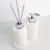 Conjunto de produtos para lavabo Santorini, composto por dois dispensadores decorativos com pedras brancas e canudos cinzas, sobre uma bandeja branca.