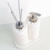 Kit lavabo Santorini com dispensador de sabonete e difusor de ambiente, decorados com pedras brancas e base branca.