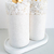 Conjunto de lavabo Santorini com dois frascos brancos e base, decorados com pedras brancas.