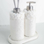 Kit Lavabo Santorini com dois dispensadores decorativos, um com bomba de metal e outro com difusor de varetas, ambos com detalhes em pedras brancas.