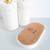 Kit Lavabo Santorini com dois recipientes brancos decorados com pedras brancas e uma base oval de cortiça.