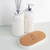 Kit Lavabo Santorini com frascos brancos decorados com pedras brancas e um suporte de cortiça.