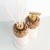 Kit lavabo Duna com dispenser e difusor, decorados com pedras naturais e detalhes em dourado.