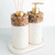 Kit Lavabo Duna com design elegante, composto por dois frascos decorativos com tampa dourada e detalhes de pedras naturais.